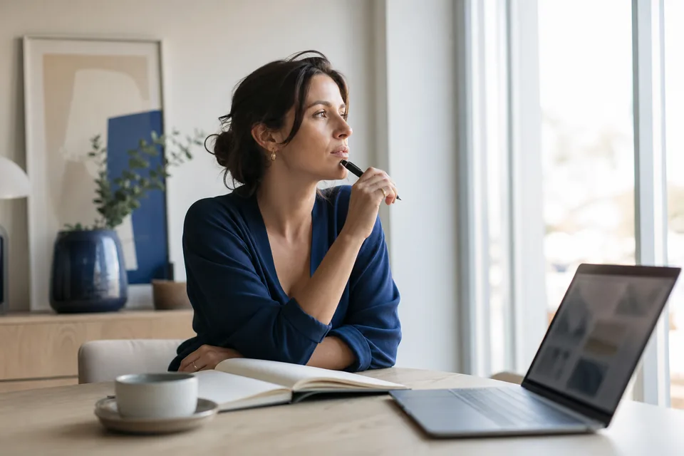 Copywriter drafting content with a notebook and laptop