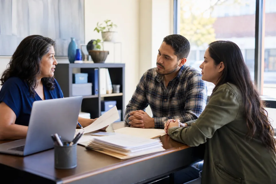 Tax preparer meeting a client couple at her storefront tax office